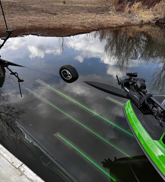 Boat trailer with waterproof LED lights glowing through Smoke Gatorbak XP bunk covers at the boat ramp