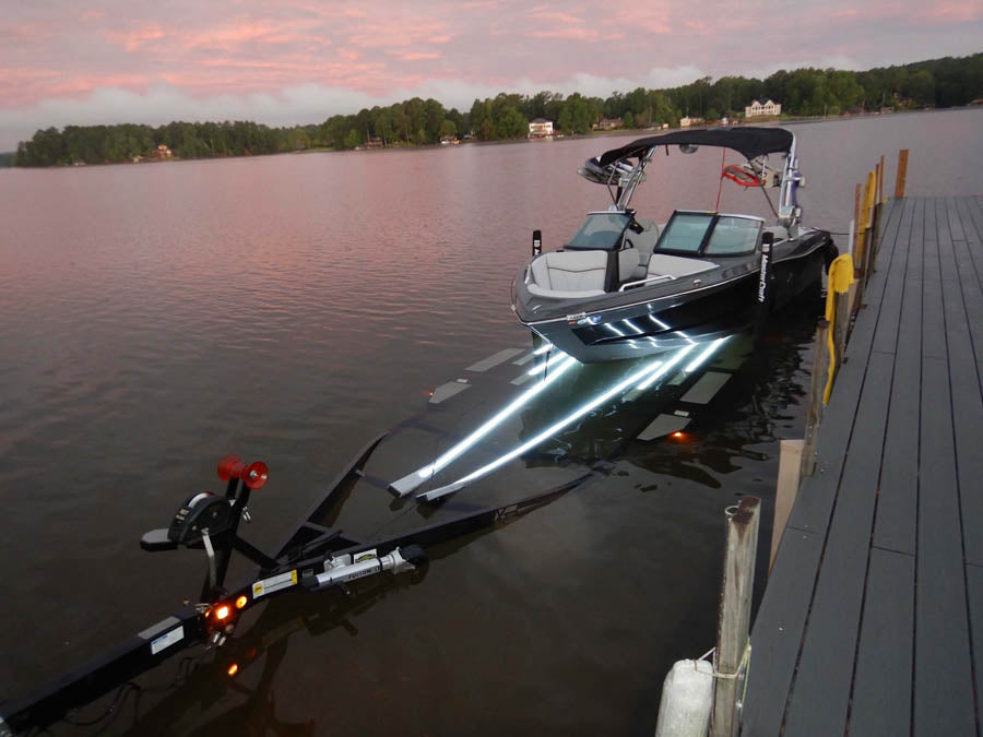 Launching Boat off Trailer near dock at dusk with lighted bunk covers